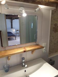 a bathroom with a mirror above a sink at Maison Village Hautefage in Hautefage
