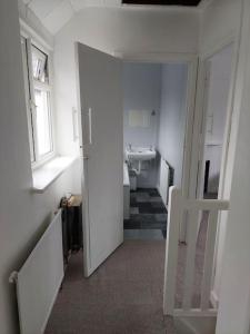 uma casa de banho branca com um lavatório e um WC em Lovely 3 bed terraced family house em Kew Gardens