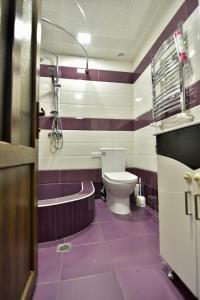 a purple bathroom with a toilet and a bath tub at Ham-uni in Elar