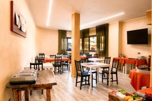 a restaurant with tables and chairs and a flat screen tv at Piccola Locanda S'Ausentu in Uri