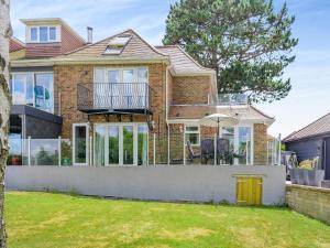 a brick house with a balcony and a yard at Still Waters in Hill Head