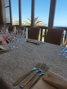 una mesa con vasos y cubiertos sobre una mesa en Hotel Il Timone, en Specchiolla