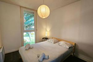een slaapkamer met een bed met twee handdoeken erop bij Ovalie ! Grand appart. 6 couchages avec parking in Montpellier