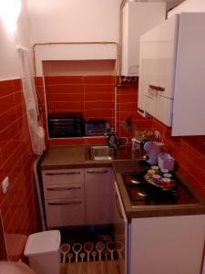 una piccola cucina con piano cottura e lavandino di Sweet home tra i due mari a Taranto