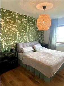 een slaapkamer met een bed met groen en wit behang bij Ennstal Classic Landhaus Chalet in Irdning
