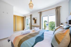 アルジェズールにあるCasa Skipのベッドルーム1室(大型ベッド1台、カラフルな毛布付)