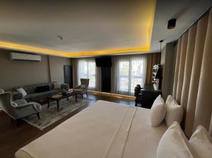 a hotel room with a bed and a living room at Bloom Suite Hotel in Kesan