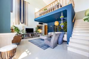 Una sala de estar con paredes azules y una escalera. en Casa Skip, en Aljezur