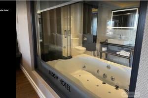 a bathroom with a bath tub and a toilet at Bloom Suite Hotel in Kesan