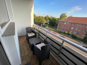 einen Balkon mit 2 Stühlen und Straßenblick in der Unterkunft Modernes Apartment/Nähe Zentrum in Magdeburg