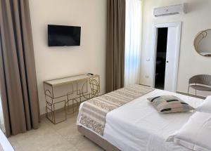 a bedroom with a bed and a television on the wall at Chiostro San Francesco - Casa di Ospitalità Religio sa in Naples