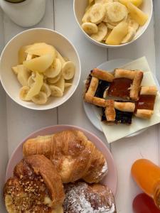 a table with plates of pastries and other breakfast foods at Bed and Breakfast Country Cottage in Civitavecchia
