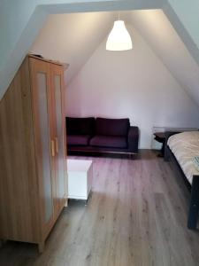 a room with a couch and a bed in a attic at Appartement in Nijmegen Kranenburg in Kranenburg