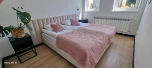 a bedroom with a bed with a pink blanket at Apartament Moje Dąbrówno in Dąbrówno