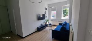 a living room with a blue couch and a table at Apartament Moje Dąbrówno in Dąbrówno