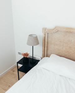 a bedroom with a bed and a lamp on a night stand at Wex Hotels in Fredrikstad