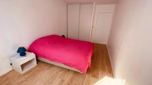Dormitorio pequeño con cama rosa y mesita de noche en Cosy 3pièces à 5min de la plage en Cannes