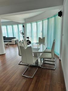 a dining room with a glass table and white chairs at Sun Gates Byala in Byala
