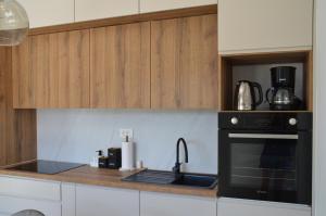 uma cozinha com um fogão e um forno preto em Honoris Apartment - Brand new - Private parking - 90 m from the beach- Terrace em Slano
