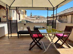 a table and chairs on a balcony with a view at Apartamento Canónigo - terraza con vistas in Toledo
