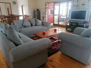 Sala de estar con 2 sofás y TV en Sundays River Mouth Guesthouse, en Colchester