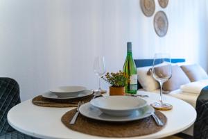 a white table with two plates and wine glasses at Businessapartment Zentral & Modern nahe Hauptbahnhof, schnelles WLAN in Essen