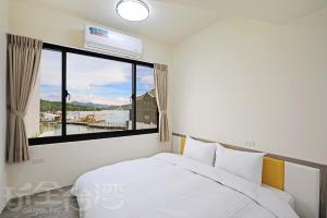 魚池鄉的住宿－開心龍民宿，一间卧室设有一张床和一个大窗户