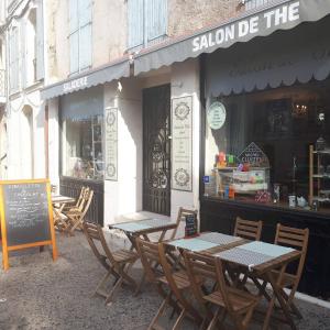 deux tables et des chaises devant un restaurant dans l'établissement Les Litanies - Centre historique Pezenas, à Pézenas