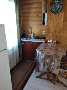 una pequeña cocina con mesa en una habitación en Cottage Lisovychok, en Vorokhta