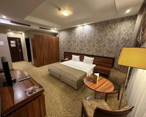 a hotel room with a bed and a desk at Jouhayna Hotel&Suite in Erbil