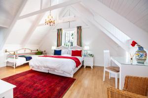 1 dormitorio con cama blanca y alfombra roja en Cosimi Guest House, en Durbanville