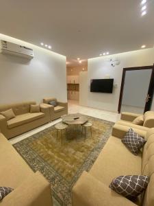 a living room with a couch and a table at دارك للوحدات السكنية in ‘Aryam