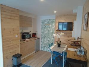 a kitchen with wooden cabinets and a table and a small table and chairs at Palaiseau - proche Orly et Paris in Palaiseau