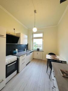 cocina con armarios blancos, mesa y ventana en 2 Schlafzimmer WaschenSpülmaschine, en Duisburg