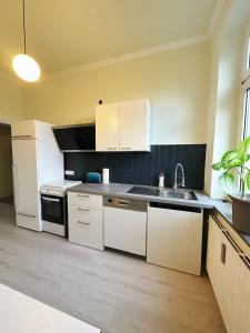 Una cocina con gabinetes blancos y un fregadero. en 2 Schlafzimmer WaschenSpülmaschine, en Duisburg 7 fotos más