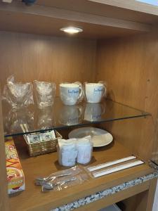 a glass shelf in a kitchen with a plate and dishes at Hotel La Rouge - Vacation STAY 89068v in Fukushima