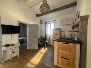 eine Küche mit einem Waschbecken und einem Tisch in einem Zimmer in der Unterkunft appartement a 50 m de la place aux herbes in Uzès