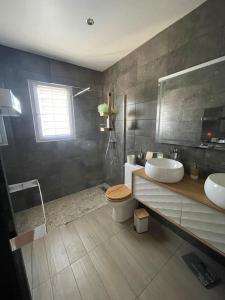 uma casa de banho com 2 lavatórios e um WC em Belle Maison au calme avec piscine em Jonquières