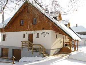 una casa con techo con nieve. en Pension Polubný 922, en Kořenov