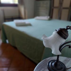 a white bird figurine on a table in front of a bed at Le Case Di S. Andrea in Buccheri