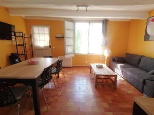 a living room with a couch and a table at Comme à la maison, T3 tout confort pour 8, jardin au calme in La Crau