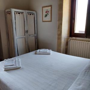 a bedroom with a large bed with two towels on it at Le Case Di S. Andrea in Buccheri
