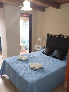 a bedroom with a blue bed with two towels on it at La Gracia in Salta