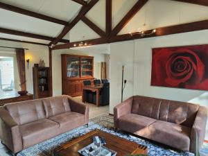 Sala de estar con 2 sofás y mesa en Spacious holiday home near with sauna, en Garderen