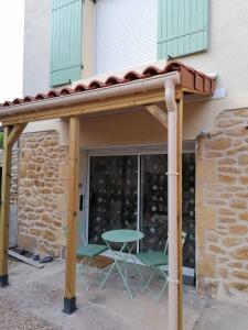 awning over a patio with a table and chairs at Studio Lindois in Lalinde
