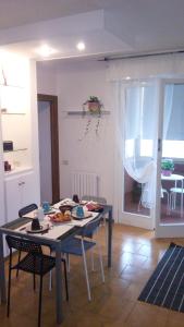 una sala da pranzo con tavolo e sedie e una stanza con tavolo di Casa Vacanze Orchidea CIR0347AT00249 a Parma
