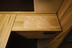 a wooden box with a menu on it in a room at Dormy Inn Korakuen in Tokyo