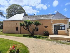 an old brick building with a tree in front of it at LE BAS CHITRAY in Ménil