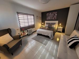 Valles de OrtegaにあるApartamento Arribaのベッドルーム1室(ベッド1台、椅子、ソファ付)