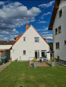 ein weißes Haus mit einer Terrasse und einem Hof in der Unterkunft Schönes Zimmer in Einfamilienhaus in ruhiger Lage in Ober-Ramstadt
